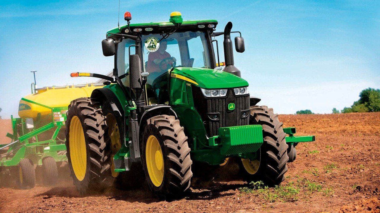 Трактор John Deere с сеялкой в поле
